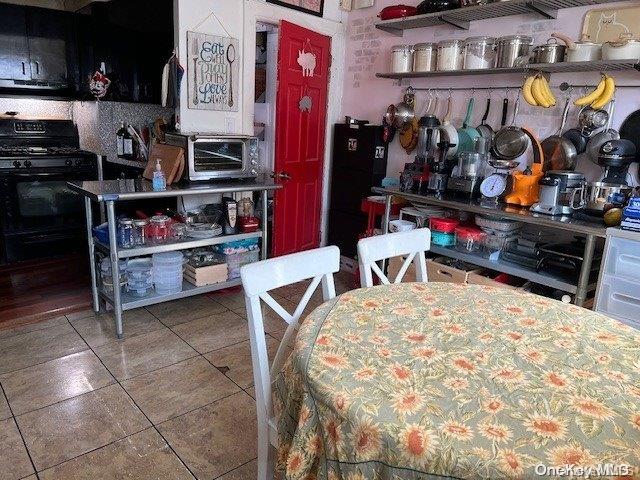 kitchen featuring black electric range and tile patterned flooring