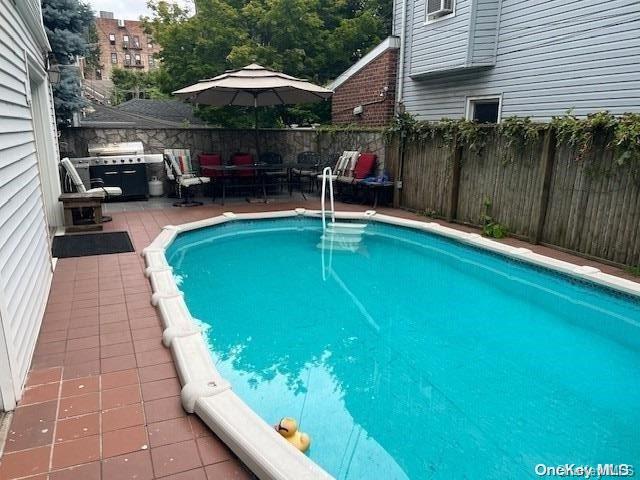 view of pool with a grill