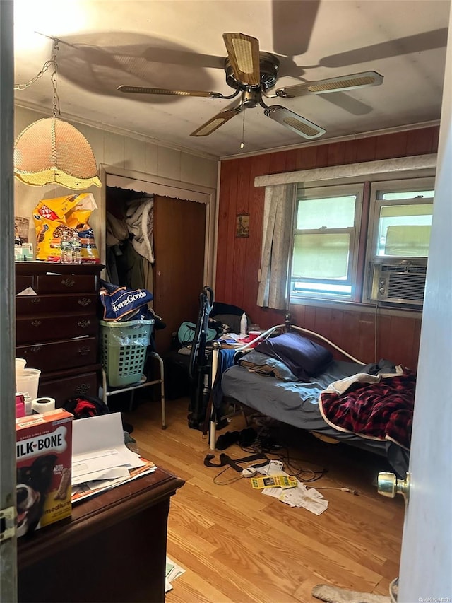 bedroom featuring hardwood / wood-style flooring, ceiling fan, cooling unit, and crown molding