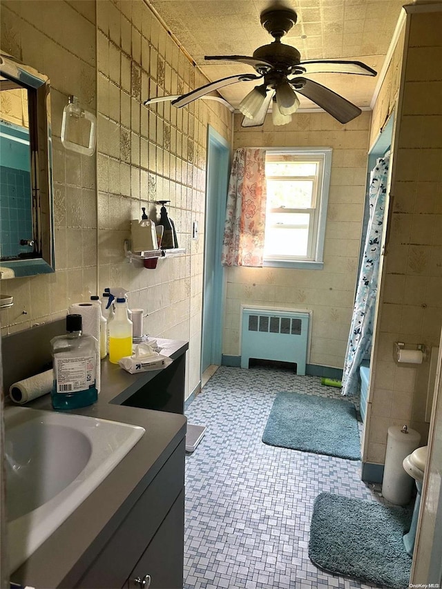 full bathroom with vanity, shower / bath combo with shower curtain, radiator heating unit, and tile walls