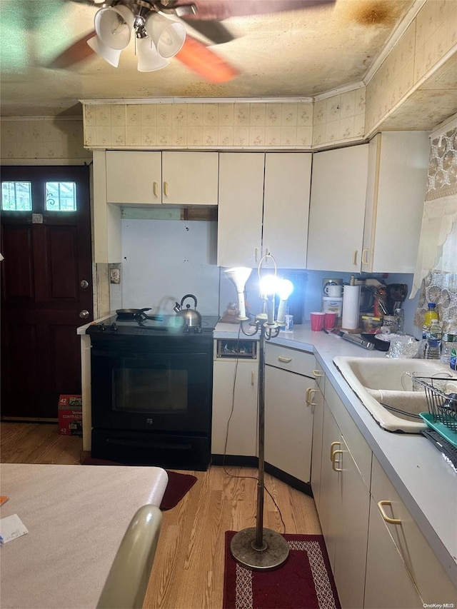 kitchen featuring light hardwood / wood-style floors, white cabinetry, sink, and black range with electric cooktop