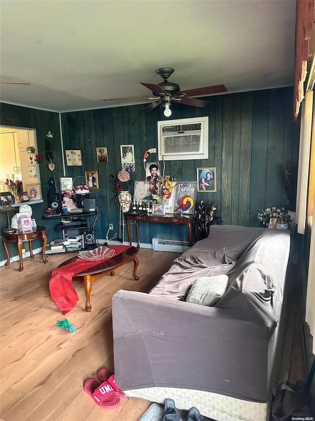 living room featuring hardwood / wood-style flooring, wood walls, baseboard heating, and a wall unit AC