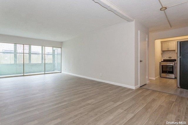 unfurnished living room featuring light hardwood / wood-style flooring and a textured ceiling