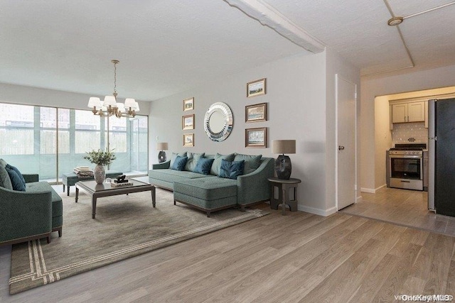 living room featuring a textured ceiling, light hardwood / wood-style floors, and an inviting chandelier