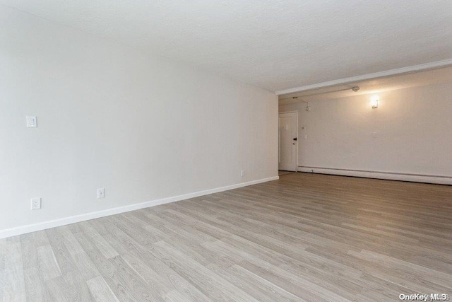 unfurnished room with light hardwood / wood-style floors, a textured ceiling, and a baseboard heating unit