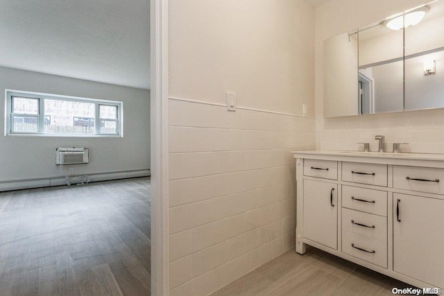 bathroom with a wall mounted air conditioner, vanity, tile walls, a baseboard radiator, and wood-type flooring