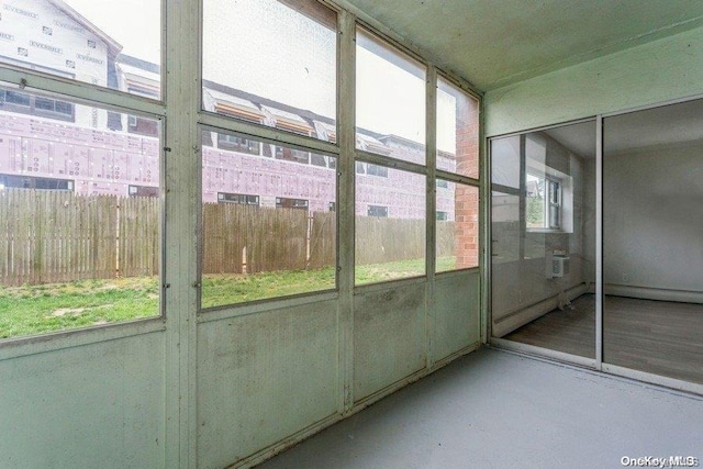 unfurnished sunroom featuring a wall mounted air conditioner