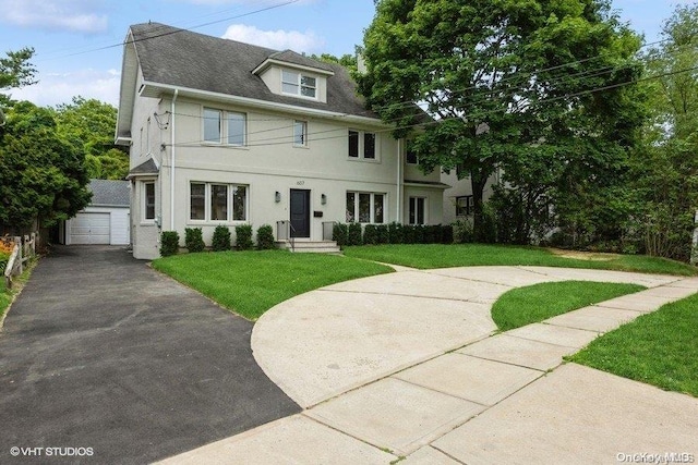 view of front of house featuring a front lawn, an outdoor structure, and a garage