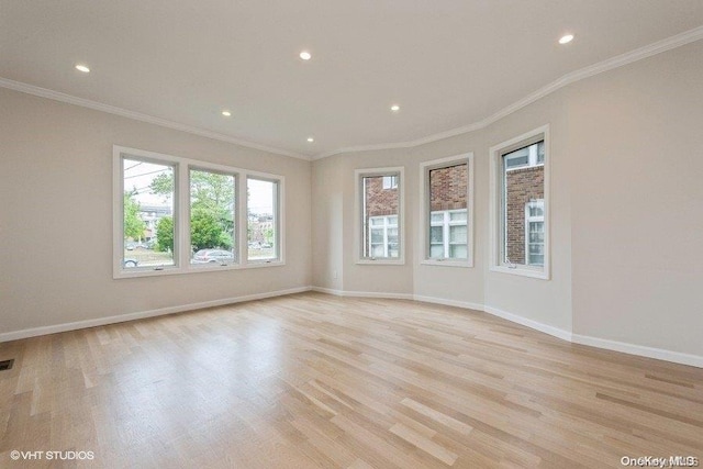 empty room with light hardwood / wood-style floors and crown molding