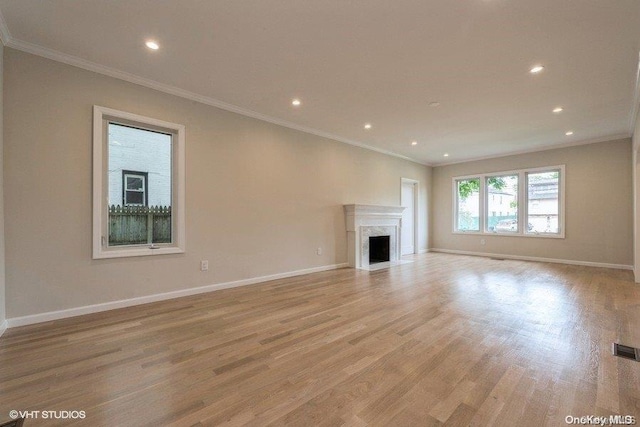 unfurnished living room with light hardwood / wood-style flooring and crown molding