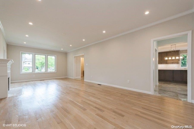 unfurnished living room featuring light hardwood / wood-style floors and crown molding