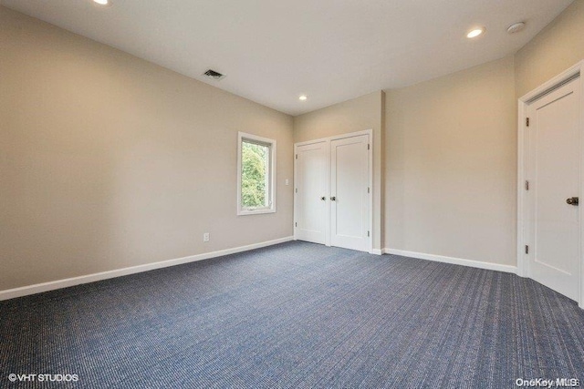 unfurnished bedroom featuring dark carpet