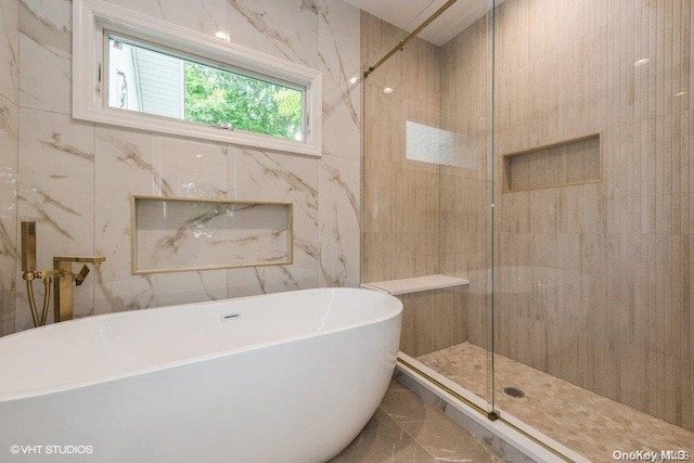 bathroom featuring tile walls and plus walk in shower