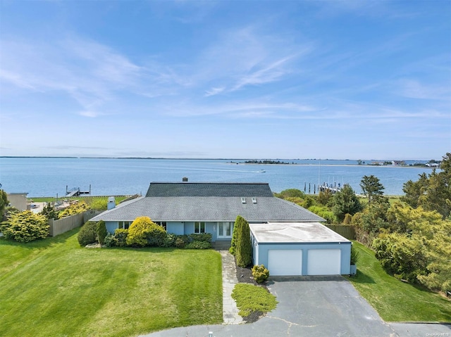 view of front of house featuring a garage, a water view, and a front lawn