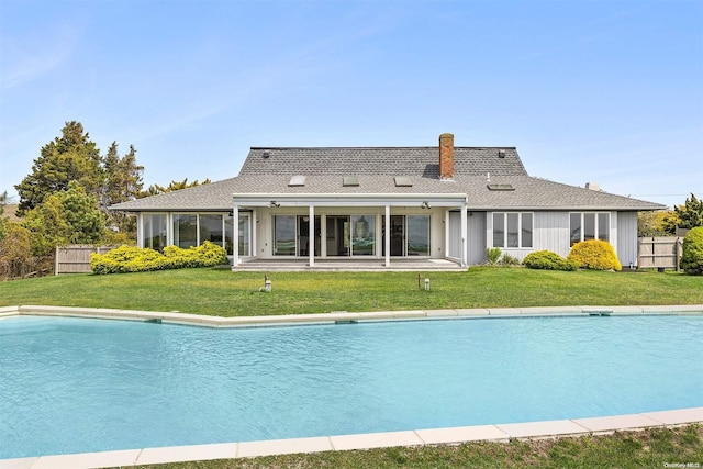 back of house featuring a yard and a sunroom