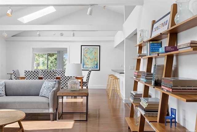 living room with wood-type flooring, rail lighting, and vaulted ceiling