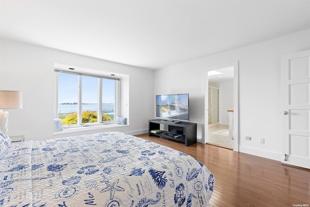 bedroom featuring wood-type flooring and ensuite bath