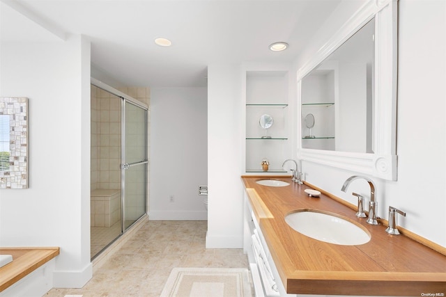 bathroom featuring tile patterned flooring, vanity, and a shower with door