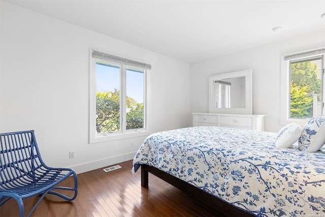 bedroom with dark hardwood / wood-style flooring