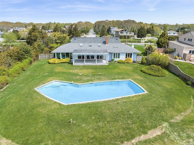 back of house with a sunroom, a fenced in pool, a yard, and a patio