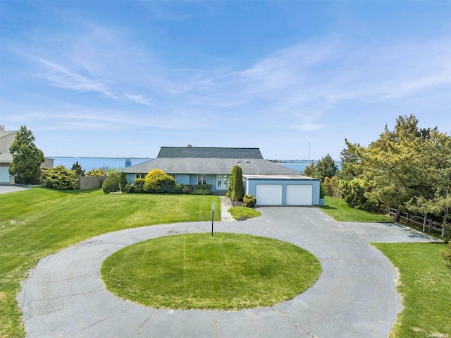 ranch-style home featuring a water view, a front yard, and a garage