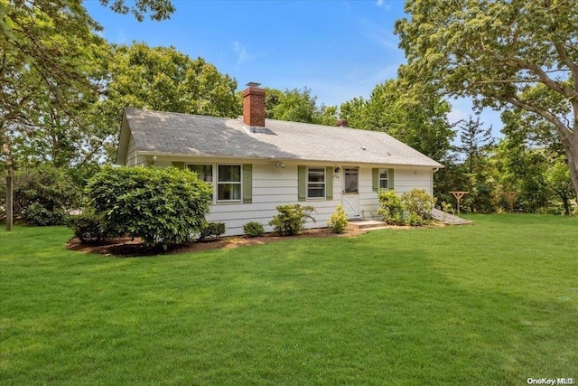 rear view of house featuring a yard