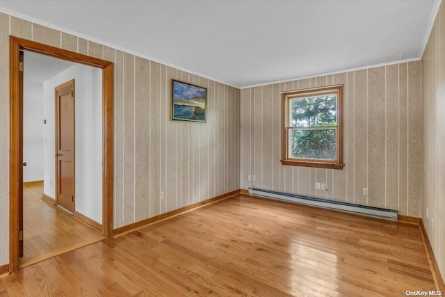 unfurnished room with light wood-type flooring, crown molding, and a baseboard heating unit