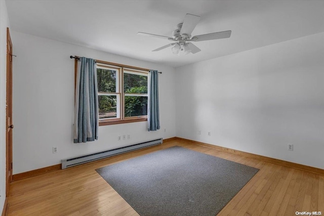 empty room featuring baseboard heating, ceiling fan, and hardwood / wood-style flooring