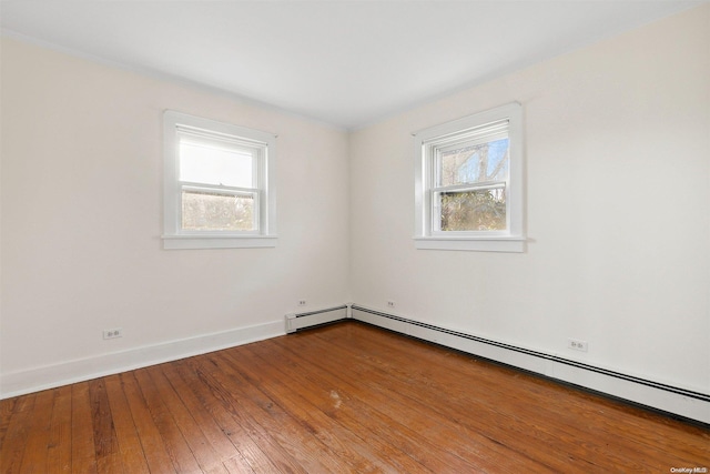 unfurnished room with a baseboard radiator and hardwood / wood-style flooring