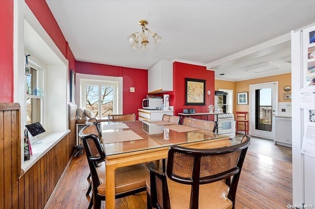 dining area featuring wood-type flooring and an inviting chandelier