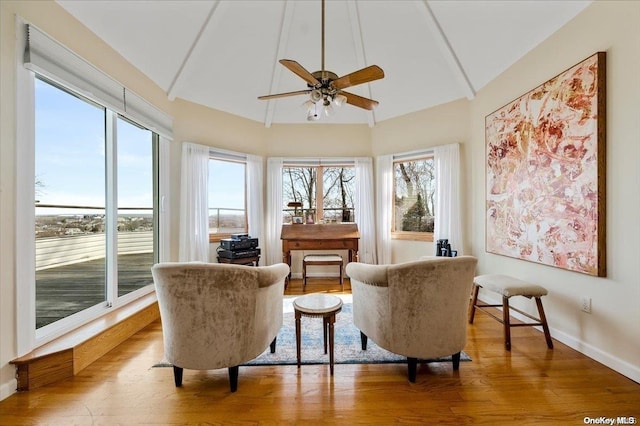 sitting room with hardwood / wood-style floors, vaulted ceiling, and ceiling fan