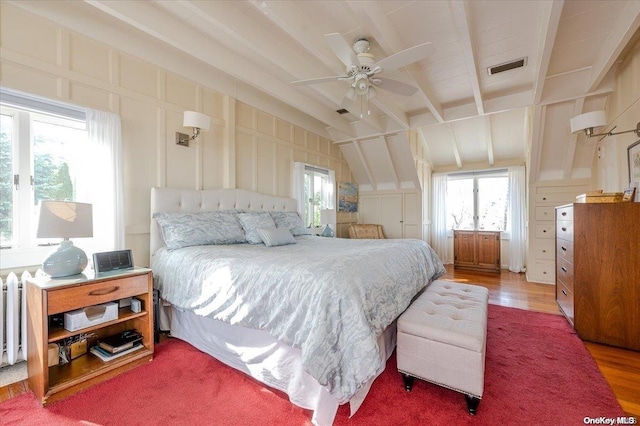 bedroom with ceiling fan, lofted ceiling with beams, and hardwood / wood-style flooring