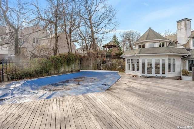 view of swimming pool with a wooden deck and french doors