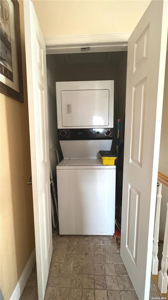 clothes washing area featuring stacked washer and clothes dryer