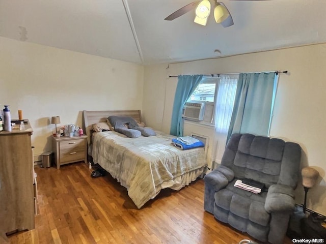 bedroom with ceiling fan, cooling unit, and wood-type flooring