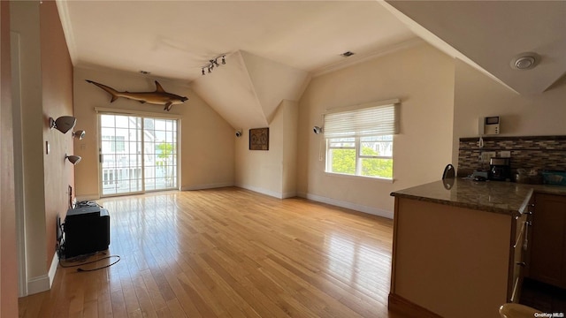 living room featuring ornamental molding, vaulted ceiling, and light wood-type flooring