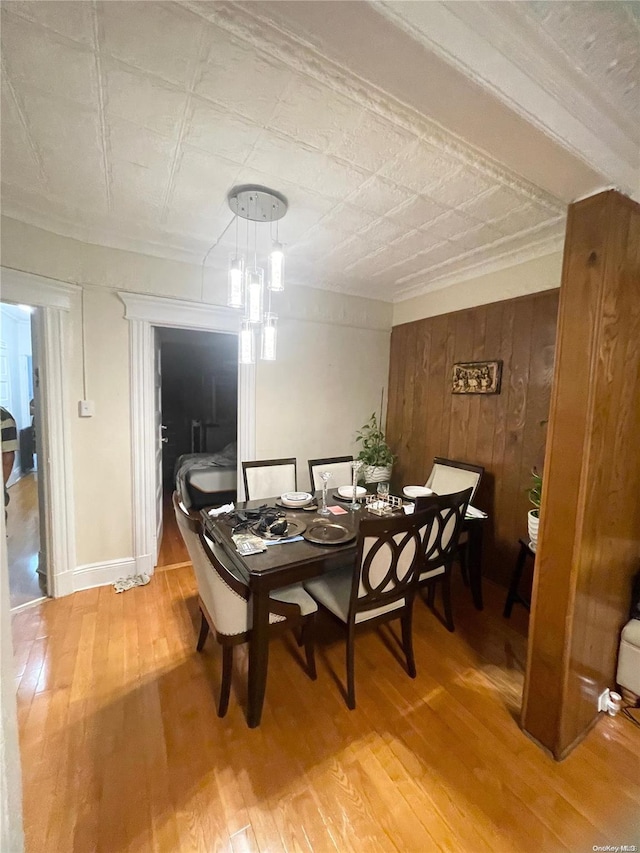 dining area featuring hardwood / wood-style floors and wooden walls