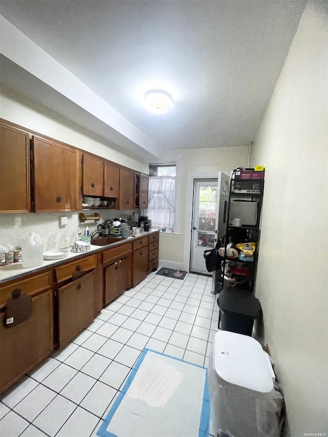 kitchen featuring light tile patterned floors and sink