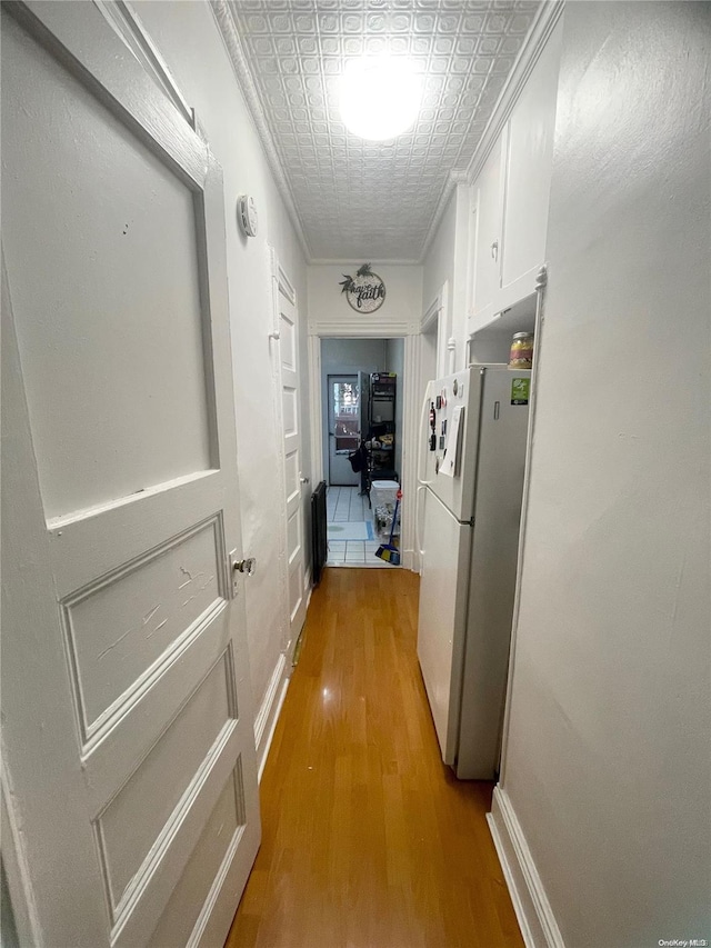 hallway with hardwood / wood-style floors and crown molding