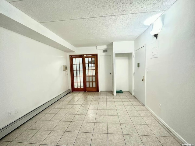 unfurnished room with french doors, a textured ceiling, light tile patterned floors, and baseboard heating