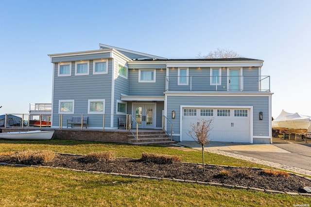 view of front of house featuring french doors, a garage, and a front lawn