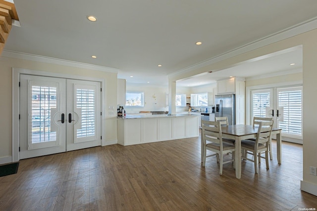 unfurnished dining area featuring french doors, dark hardwood / wood-style flooring, plenty of natural light, and ornamental molding