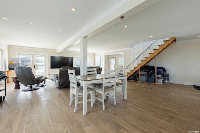 dining room featuring beam ceiling, light wood-type flooring, and crown molding