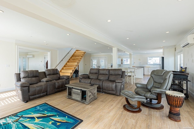 living room featuring an AC wall unit, light hardwood / wood-style flooring, and ornamental molding