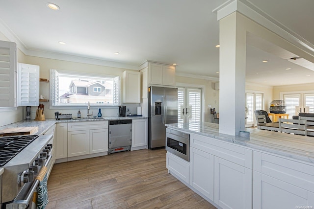 kitchen featuring white cabinets, stainless steel appliances, light hardwood / wood-style floors, and sink