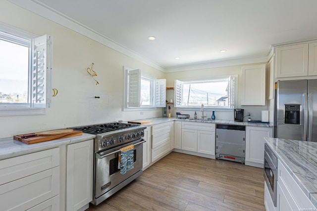 kitchen featuring sink, stainless steel appliances, light stone counters, light hardwood / wood-style flooring, and crown molding