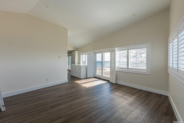 spare room featuring lofted ceiling and dark hardwood / wood-style floors