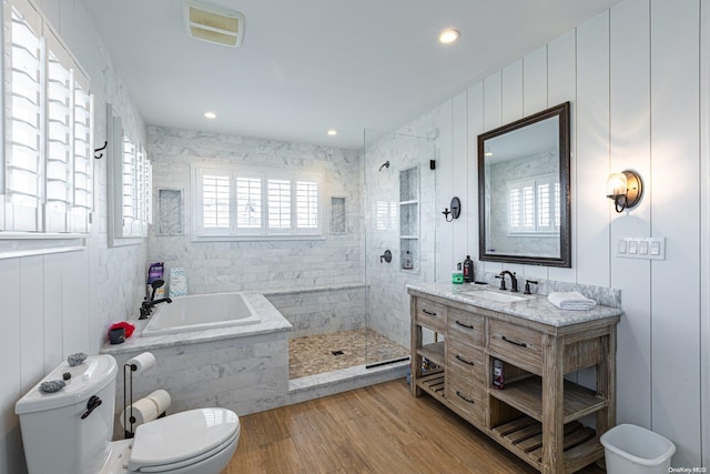 full bathroom with hardwood / wood-style floors, vanity, toilet, and independent shower and bath