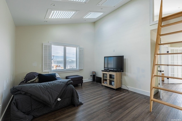 bedroom with high vaulted ceiling and dark wood-type flooring