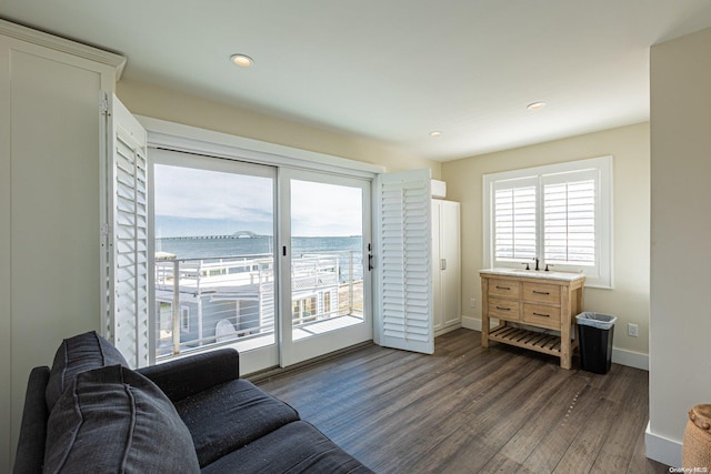 living room featuring dark hardwood / wood-style flooring and a water view